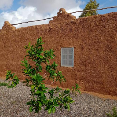 a red brick wall with a window on it at Ngayan Camp in Marrakech