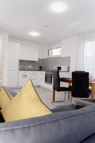 a kitchen with a couch and a table with chairs at GrenzApartments in Bietingen