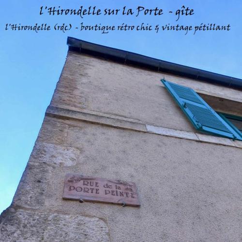 un panneau sur le côté d'un bâtiment avec une fenêtre dans l'établissement l'Hirondelle sur la Porte, à Noyers-sur-Serein