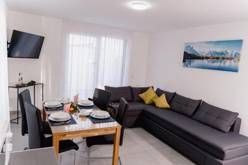 a living room with a couch and a table at GrenzApartments in Bietingen