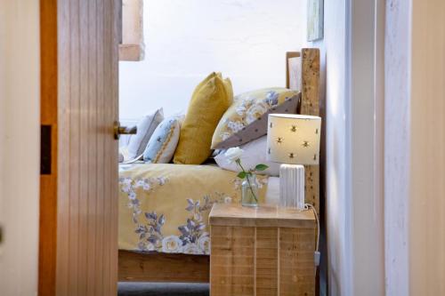 a room with a bed and a table with a lamp at Rose Cottage in Paignton