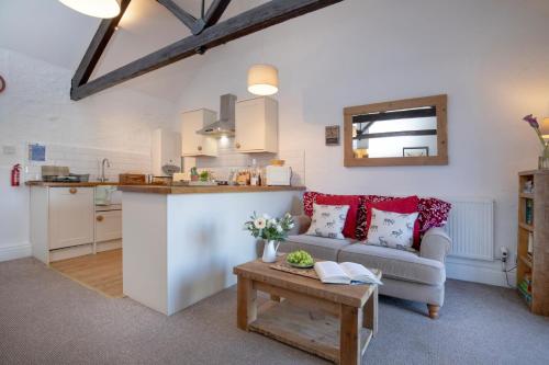 a living room and kitchen with a couch and a table at Rose Cottage in Paignton