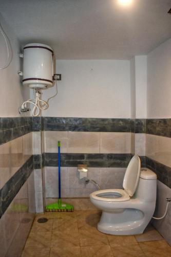 a bathroom with a toilet and a water tank at Rustic wood house - A village home stay in Jibhi Valley in Jibhi