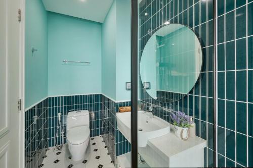 a bathroom with a toilet and a sink and a mirror at La isla Apartments & Villas - Sea View & Fireworks Phu Quoc in Phu Quoc