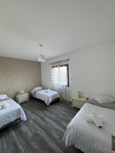 a room with three beds and a window at Villa Entière in Montauban