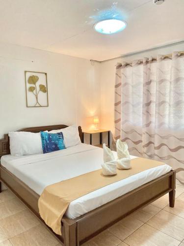 a bedroom with two beds and a window at Seashells Home in Panglao Island