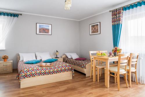 a bedroom with two beds and a table and a dining room at Pod Źródełkiem in Cisna