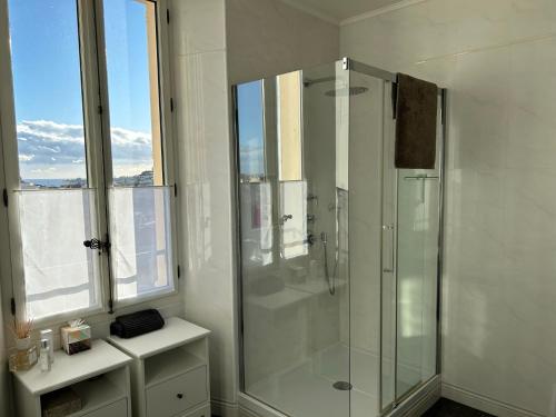 La salle de bains blanche est pourvue d'une douche et d'une fenêtre. dans l'établissement Spacieux proche Palais Festival, à Cannes