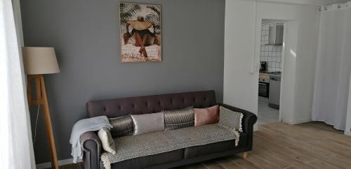 - un canapé dans le salon avec une photo sur le mur dans l'établissement maison de campagne, à Bazillac