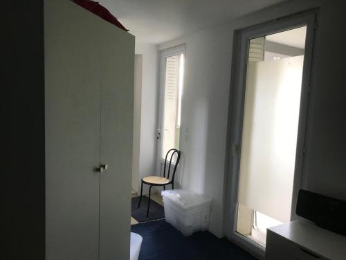 Cette chambre comprend un miroir, une chaise et une fenêtre. dans l'établissement Chambre pour 2 à Fontenay, à Fontenay-sous-Bois