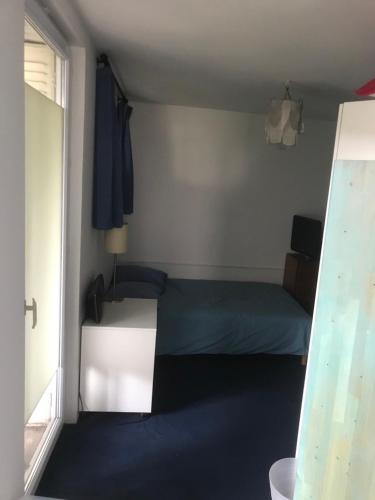 une petite chambre avec deux lits et une fenêtre dans l'établissement Chambre pour 2 à Fontenay, à Fontenay-sous-Bois