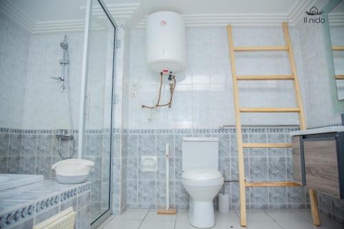 a bathroom with a toilet and a glass shower at Il Nido in Cotonou
