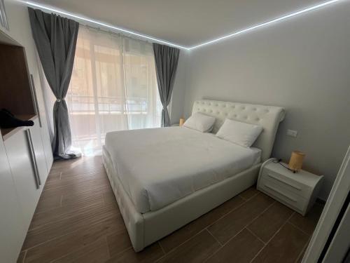 una camera da letto con un letto bianco e una finestra di Appartamento Esclusivo in Monaco Palace Josephine a Beausoleil