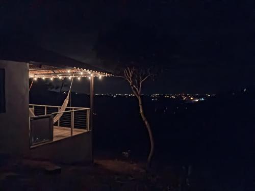 a tree on a deck at night with lights at Cabañas Laguna Bella - Bella in San Carlos