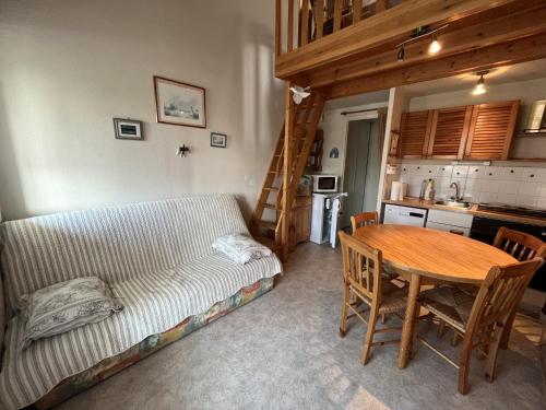 a bedroom with a bed and a table and a kitchen at Les Fermettes in Saint-Jean-de-Monts