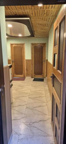 an empty room with wooden doors and a tile floor at MEHTA Guest House in Rāmpur