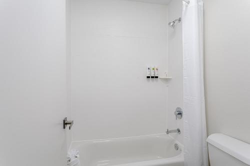 a white bathroom with a tub and a sink at Surf & Sand Hotel in Pensacola Beach