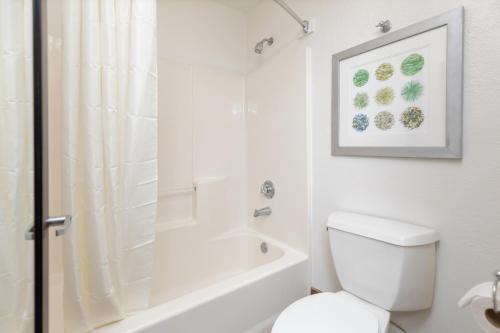 a white bathroom with a toilet and a shower at Surf & Sand Hotel in Pensacola Beach