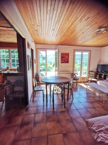une salle à manger avec une table et des chaises dans une pièce dans l'établissement Le Chalet D'en Paradis, à Serrières-sur-Ain