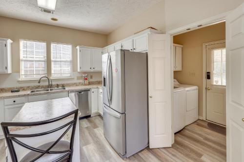 a kitchen with a stainless steel refrigerator and white cabinets at Home with Fenced Yard about 12 Mi to Dtwn Montgomery in Mitylene