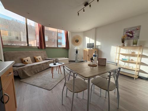 un salon avec une table et un canapé dans l'établissement L'appartement Tour du Reuze, à Dunkerque