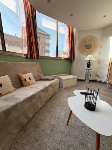 un salon avec un canapé et une table dans l'établissement L'appartement Tour du Reuze, à Dunkerque