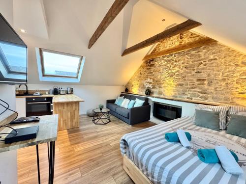 a bedroom with a bed and a stone wall at Studio cosy - renove - calme - 3 personnes - proche gare et centre historique in Quimper