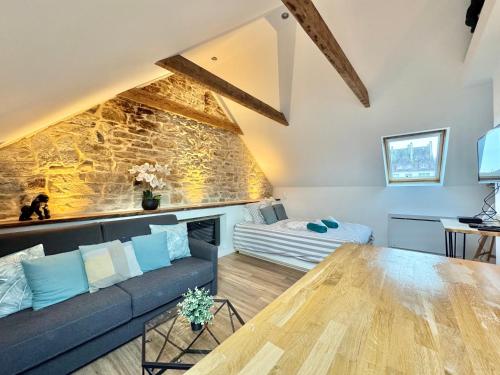 un salon avec un canapé et une table dans l'établissement LE CALLOCH 3G - Superbe Studio - Quartier Gare - Wifi - Netflix, à Quimper