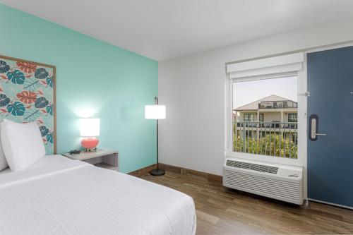 a bedroom with a white bed and a window at Surf & Sand Hotel in Pensacola Beach
