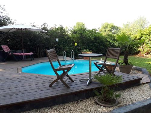 - une terrasse avec 2 chaises et une table à côté de la piscine dans l'établissement La Chambrette, à Salon-de-Provence