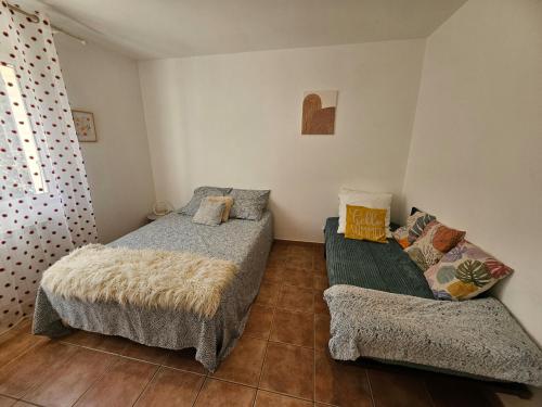 une petite chambre avec deux lits et un canapé dans l'établissement Maison des Fenaisons, à Entraigues-sur-la-Sorgue