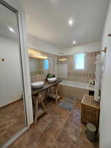 une salle de bain avec deux lavabos et une baignoire dans l'établissement Maison des Fenaisons, à Entraigues-sur-la-Sorgue