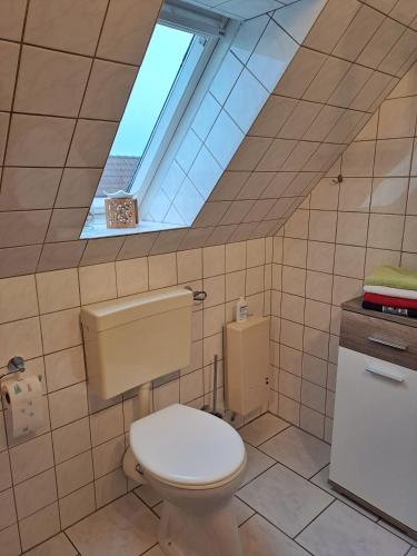 a bathroom with a toilet and a skylight at Ferienwohnung Sternschnuppe in Dülmen