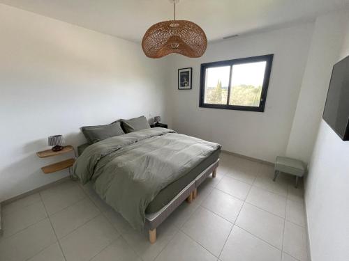 une chambre avec un grand lit et une fenêtre dans l'établissement Villa contemporaine avec piscine, à Sussargues