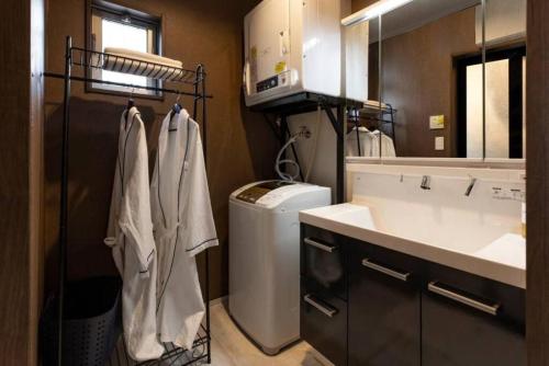 łazienka z umywalką i pralką w obiekcie Vacation Rental Motobu Grande BBQ機材完備 w mieście Motobu
