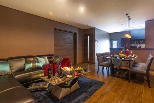 a living room with a leather couch and a table at Vacation Rental Motobu Grande BBQ機材完備 2卫 4车位 15人 in Motobu