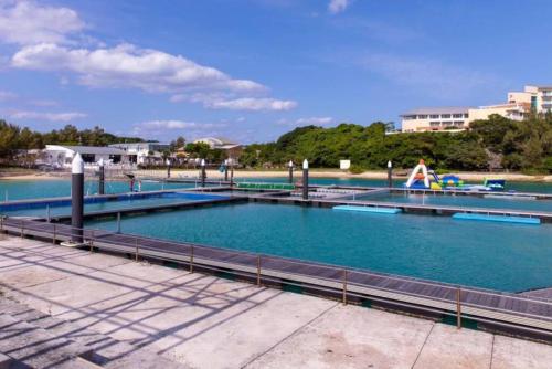 a large swimming pool with blue water at Vacation Rental Motobu Grande BBQ機材完備 2卫 4车位 15人 in Motobu