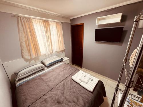 a bedroom with a bed and a television in a room at Charme e Conforto a 10 Min da Ponte JK, 2 suítes in Brasilia