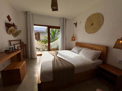 a bedroom with a bed and a large window at Villa Maria - Serra Grande in Uruçuca