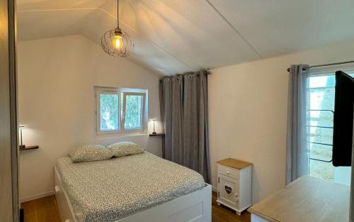 une petite chambre avec un lit et une fenêtre dans l'établissement Tilou Location - Giens - proche des plages et du villages, à Hyères