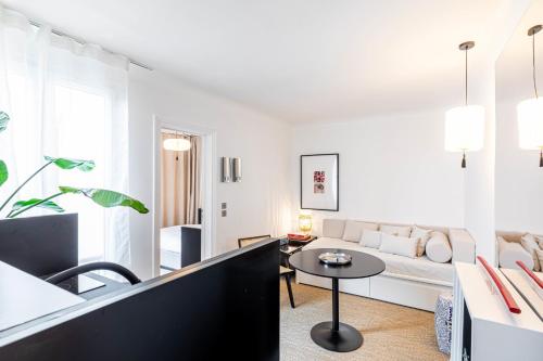 un salon blanc avec un canapé et une table dans l'établissement Flexliving - T2 - Crozatier, à Paris
