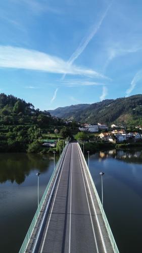 a bridge over a body of water with a town at Douro Hotel Porto Antigo in Cinfães