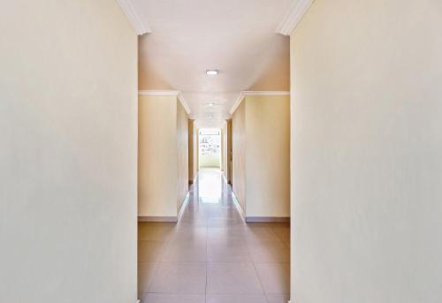 an empty hallway with white walls and tile floors at Super Hotel O Golden Hive Madhapur Near Shilparamam in Hyderabad