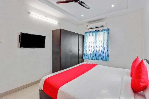 a bedroom with a bed and a tv on the wall at Super Hotel O Golden Hive Madhapur Near Shilparamam in Hyderabad