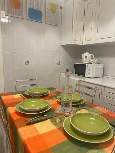 a kitchen with a table with green plates on it at La Casa nel Parco by Smart-Home in Vallecrosia