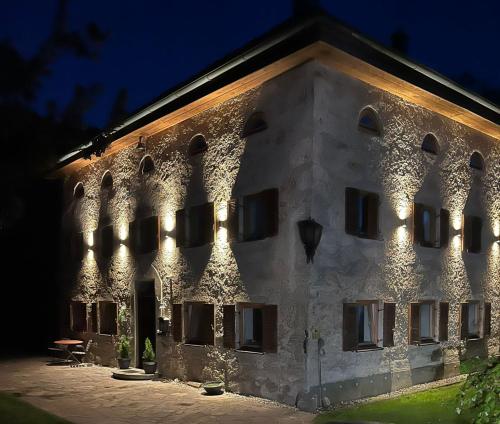 a building with lights on it at night at Burg 2 - Ferienwohnungen in Taching am See