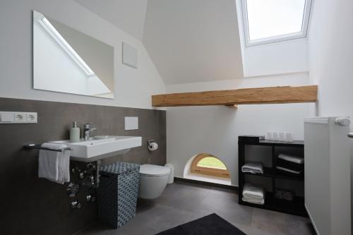 a bathroom with a sink and a toilet at Burg 2 - Ferienwohnungen in Taching am See