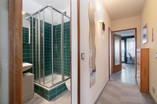 a bathroom with green tiles and a glass shower at Ferienpark Sierksdorf App 382 - Strandlage in Sierksdorf