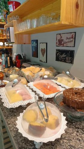 a counter with many different types of food on plates at Pousada Sítio da Floresta in Sana
