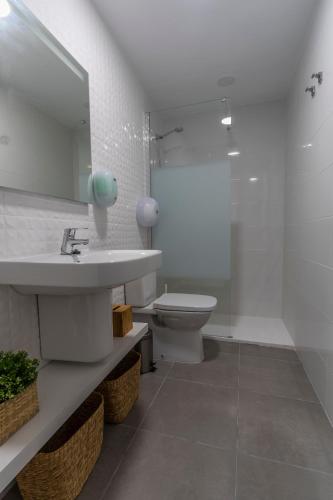 a bathroom with a sink and a toilet and a mirror at MM-Rooms in San Javier